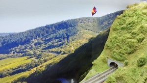 Mutiger Gleitschirmflieger über der Brücke