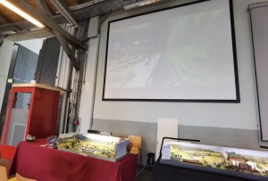 Allgäu Anlage von Alois links, dahinter die Kamerawagenübertragung via Beamer auf der Projektionsfläche. Rechts meine Anlage Klapplingen angeschnitten.