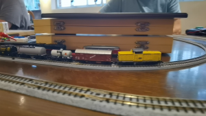 V100 Ost in Bauzug-gelb vor Güterzug. Basis ist Märkln V100 West. Hütchen von Michael Hering.